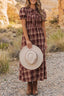 Woman wearing a red western plaid tie-front puff-sleeve midi dress with brown boots