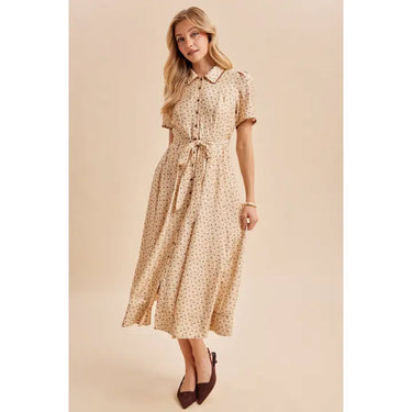 Woman wearing a buttercream floral button-down tie-waist maxi dress