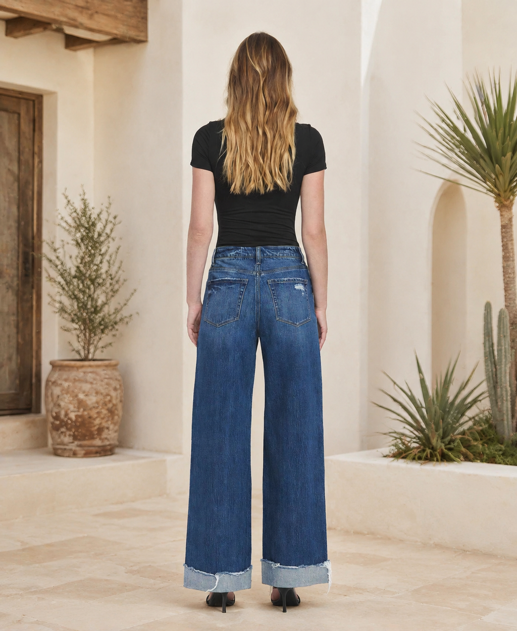 Back view of women’s dark-wash cuffed baggy jeans showing five-pocket styling