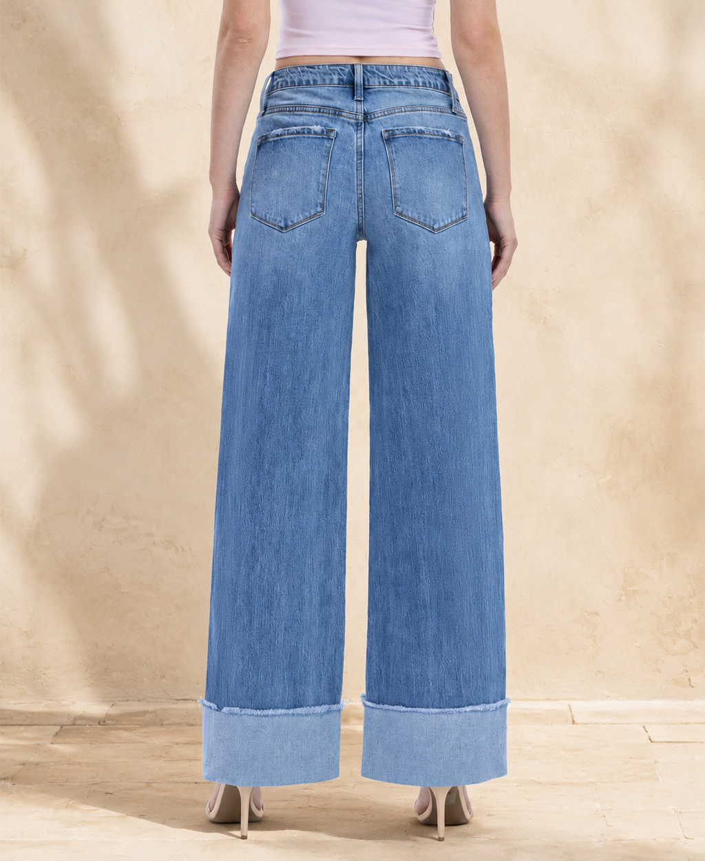Back view of medium-wash cuffed wide-leg jeans showing rear pocket styling