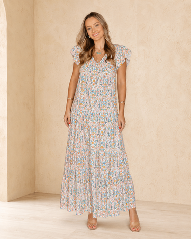 Front view of an ivory horseshoe floral tiered maxi dress with ruffle cap sleeves